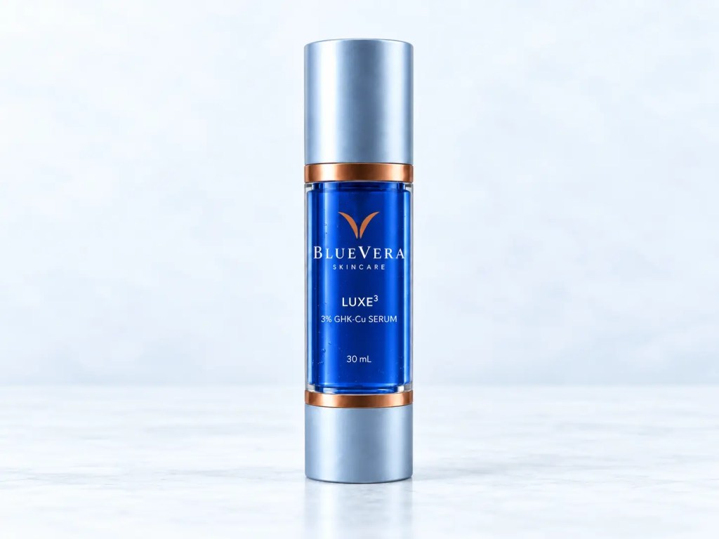 BlueVera LUXE³ 3% GHK-Cu serum in a cobalt-blue airless bottle on a cool blue-white studio background.